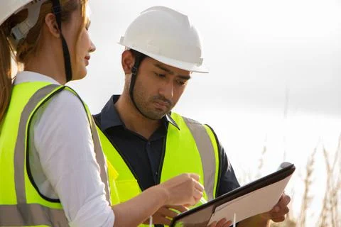 Engineer team working in wind turbine farm. Renewable energy with wind genera Stock Photos