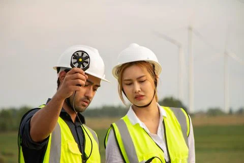 Engineer team working in wind turbine farm. Renewable energy with wind genera Stock Photos