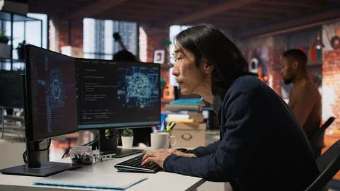 Engineer in tech startup office using AI machine learning systems on PC Stock Photos