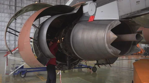 Engineer, technician examines the jet engine with a flashlight. Stock Footage 98002548