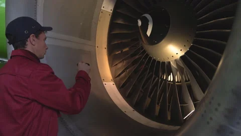 Engineer, technician examines the jet engine with a flashlight. Stock Footage 98003376