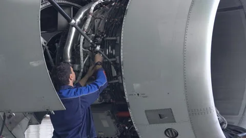 Engineer, technician examines the jet engine with a flashlight. Stock Footage 107285669