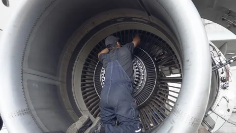 Engineer, technician examines the jet engine with a flashlight. Stock Footage 107285817
