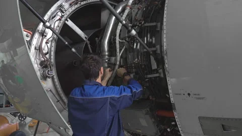 Engineer, technician examines the jet engine with a flashlight. Stock Footage 107286075