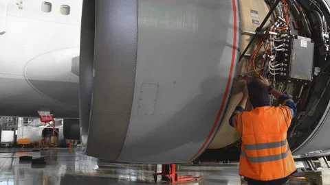 Engineer, technician examines the jet engine with a flashlight. Stock Footage 107286447