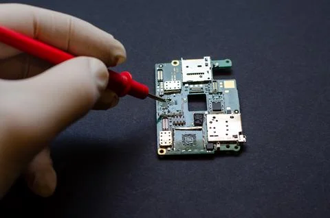 An engineer technician holds a chip and tools for repairing electronic gadget Stock Photos