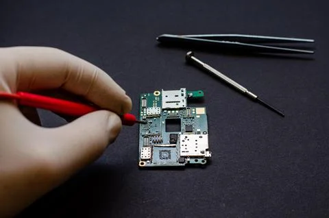 An engineer technician holds a chip and tools for repairing electronic gadget Stock Photos