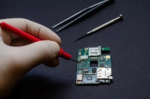 An engineer technician holds a chip and tools for repairing electronic gadget Stock Photos