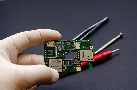 An engineer technician holds a chip and tools for repairing electronic gadget Stock Photos