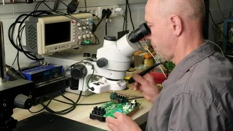 The Engineer Technician solders circuit board under the microscope. Stock Footage 246272013