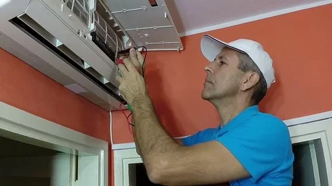 Engineer Testing Air Conditioner With Digital Measuring Instrument Stock Footage 69198607