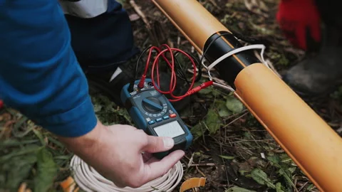 An engineer testing the cable resistance in a plastic gas pipe. Stock Footage 318268370