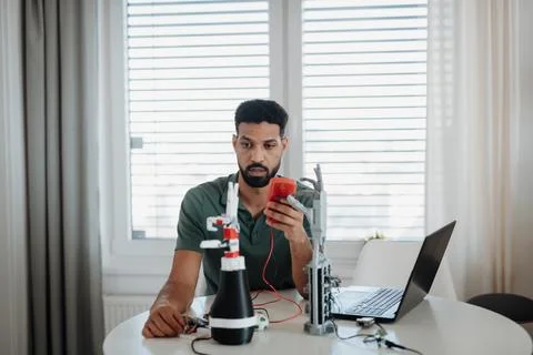 Engineer testing robotic arm circuitry using a multimeter. Fotos de archivo