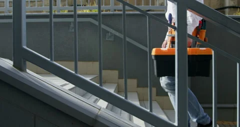 An engineer with tools in a suitcase climbs the street stairs Video stock 254725314