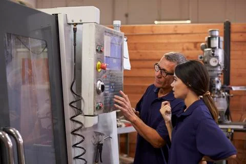 Engineer Training Female Apprentice On CNC Machine Foto stock