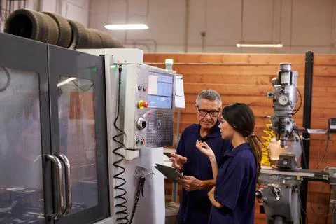 Engineer Training Female Apprentice On CNC Machine Stock Photos