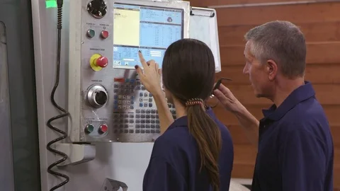 Engineer Trains Female Apprentice On CNC Machine  Stock Footage 72512397