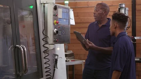 Engineer Trains Male Apprentice On CNC Machine  Video stock 72512427