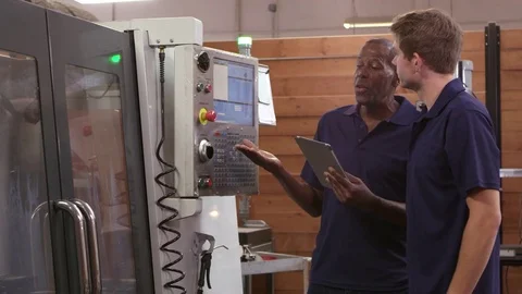 Engineer Trains Male Apprentice On CNC Machine Video stock 72512431