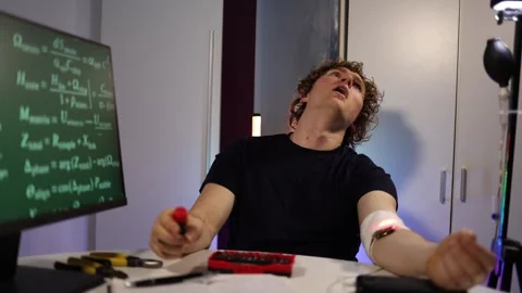 Engineer tuning cybernetic arm implant while coding neural systems in home lab Stock Footage 324443347