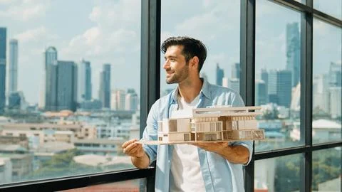Engineer turns house model left and right to check mistake point. Tracery Stock Photos
