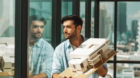 Engineer turns house model left and right to check mistake point. Tracery Stock Photos