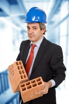 Engineer with two bricks and blue hardhat Stock Photos