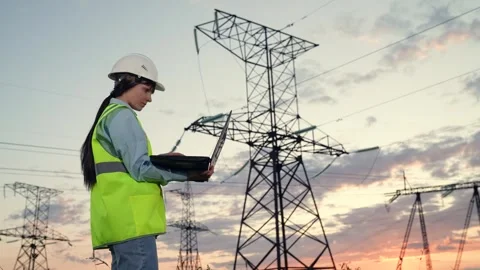 Engineer types on laptop keyboard reporting about power transmission lines Stock Footage 258334249