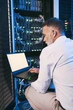 Engineer, typing and man with laptop screen in server room, online and system Foto stock