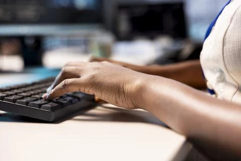 Engineer typing on keyboard, reconfiguring server farm, close up Foto stock