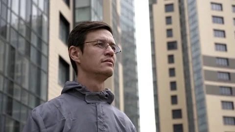 Engineer in uniform looking around with building on the background. Stock Footage
