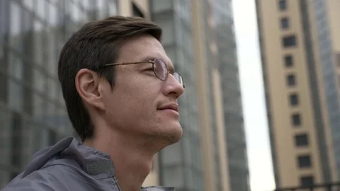 Engineer in uniform removes glasses with building on the background. Stock Footage 78023513