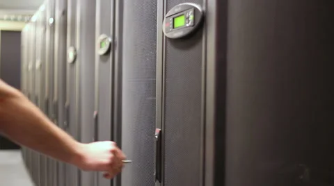 Engineer unlocks door of server rack with hard drives Stock Footage 31209876