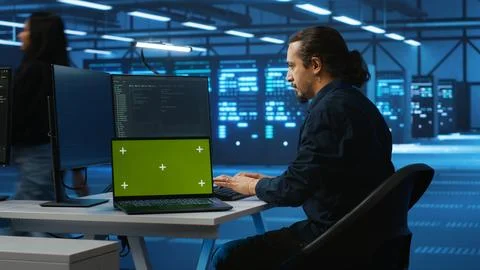 Engineer upgrading equipment in data center using green screen laptop 스톡 사진