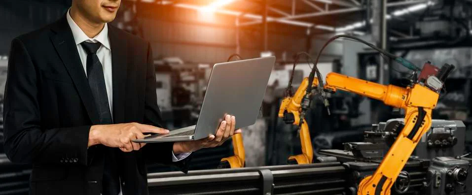 Engineer use advanced robotic software to control industry robot arm in factory Foto stock