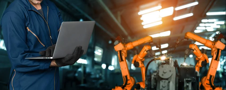 Engineer use advanced robotic software to control industry robot arm in factory Stock Photos