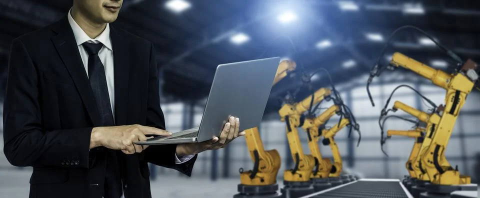 Engineer use advanced robotic software to control industry robot arm in factory Stock Photos