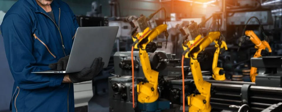 Engineer use advanced robotic software to control industry robot arm in factory Stock Photos