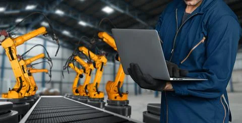 Engineer use advanced robotic software to control industry robot arm in factory Stock Photos