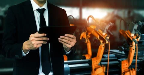 Engineer use advanced robotic software to control industry robot arm in factory 스톡 사진