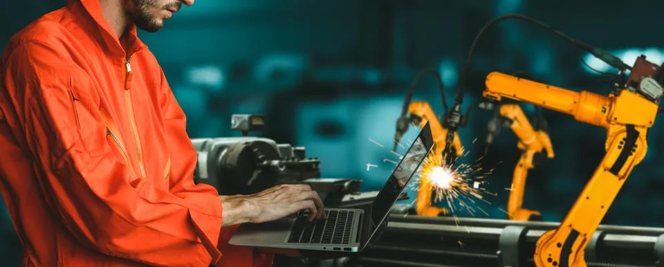 Engineer use advanced robotic software to control industry robot arm in factory Stock Photos