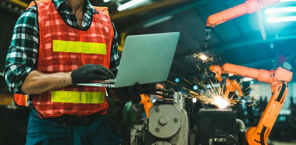 Engineer use advanced robotic software to control industry robot arm in factory Stockfoto's