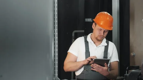 An engineer uses a computer tablet to inspect gas equipment. Stock Footage 306814703