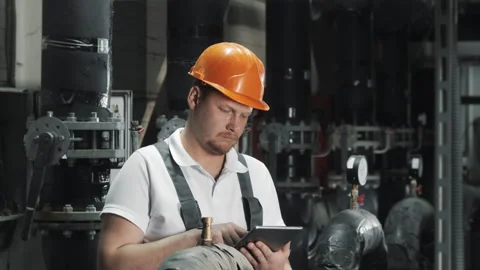 An engineer uses a computer tablet to inspect gas equipment. Stock Footage 306815764