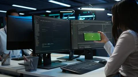 Engineer uses mockup smartphone device in server hub Stock Photos