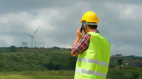 Engineer uses a smartphone to discuss wind turbine teamwork techniques Stock-Footage 143002886