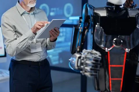Engineer using digital tablet to connect with robot 写真素材
