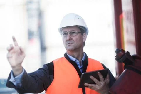 Engineer using digital tablet at port Stock Photos