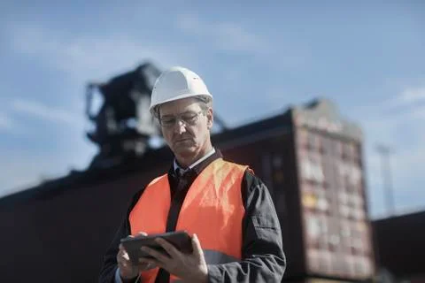 Engineer using digital tablet at port Stock Photos