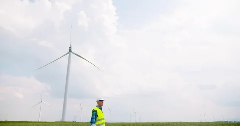 Engineer using digital tablet at windmill farm Stock Footage 98856033